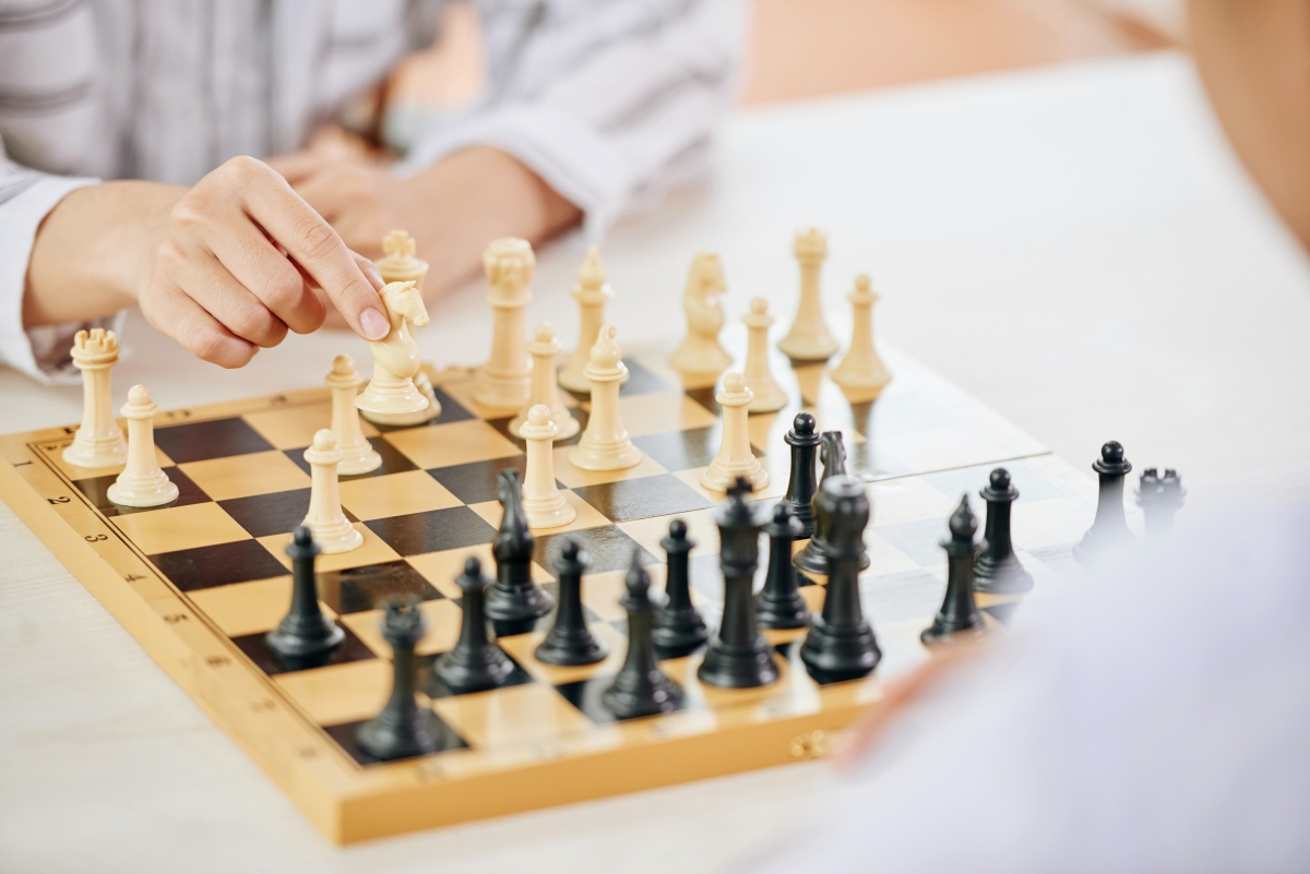 People playing chess game at table Precio alquiler autocaravanas 4 plazas